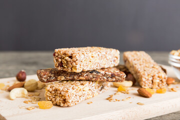 Various granola bars on table background. Cereal granola bars. Superfood breakfast bars with oats, nuts and berries, close up. Superfood concept