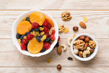 healthy snack: mixed nuts and dried fruits in bowl on table background, almond, pineapple, cranberry, cherry, apricot, cashew