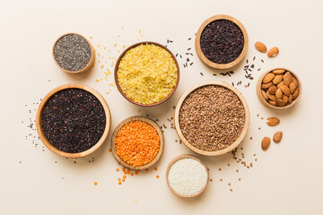 Various superfoods in smal bowl on colored background. Superfood as rice, chia, quinoa, lentils, nuts, sesame seeds, almonds. top view copy space