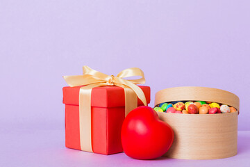 Valentine day composition: sweet candy, with gift boxes with bow and red felt hearts, photo...