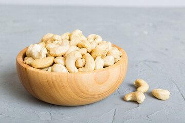 cashew nuts in wooden bowl on table background. top view. Space for text Healthy food