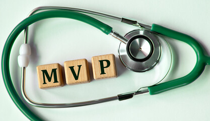 Cubes with the abbreviation MVP on the background of a stethoscope.