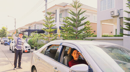 Senior security guards take care female residents with friendliness facilitating parking on the...