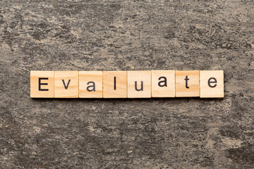 Fototapeta premium EVALUATE word written on wood block. EVALUATE text on cement table for your desing, concept