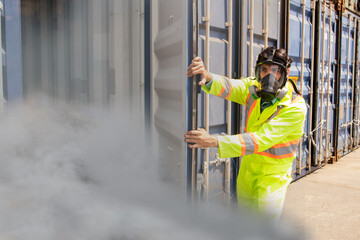 male rescue worker ppe wearing mask protection inspects tank containing dangerous poison illegal shipping containers prevent toxic dangerous gas in the loading yard dock gently open the door cover.