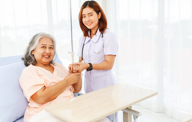 Fototapeta premium Female doctor holds the hand elderly female patient showing positive expressions encouragement good wishes each other heal sick person normal healthy spread happiness together in the hospital.