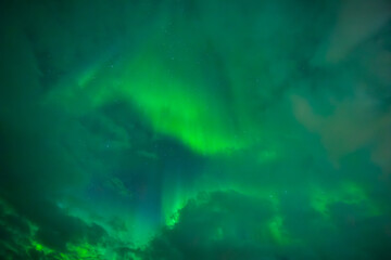 Fototapeta na wymiar Northern lights between the Clouds, Aurora Borealis