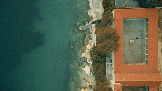 Aerial top down view of a Mediterranean seaside villa with frame-like patio