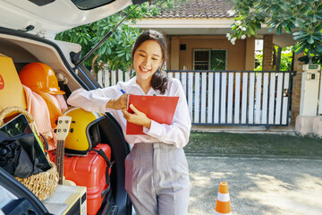 Beautiful asian businesswoman with successful business, preparing to move moving luggage in trunk...