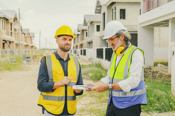 Architect who designs house consults with chief contractor worker male painter holds color...