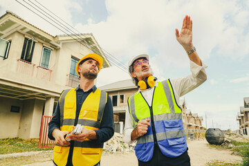 Architect who designs house consults with chief contractor worker male painter holds color...