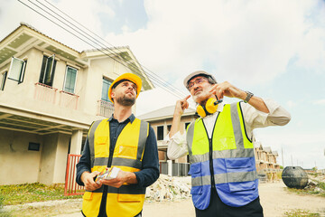 Architect who designs house consults with chief contractor worker male painter holds color...