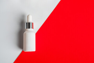 Cosmetic product in tube, bottle, lotion or serum on red and white background 