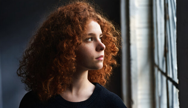 Dreaming redhead lady: portrait of a beautiful and attractive young woman, with curly hair