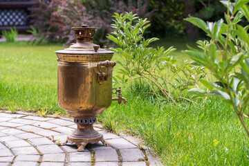 Tea party in the garden. A large copper kettle on the lawn in the garden. High quality photo