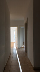 Fototapeta na wymiar Hallway with white walls and tiles. There are open doors showing the rooms