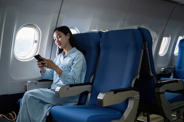 Asian people female person onboard, airplane window, using mobile while on the plane