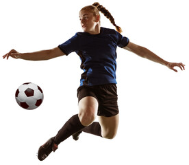 Full-length image of young girl, football player dribbling ball with leg in a jump isolated over...