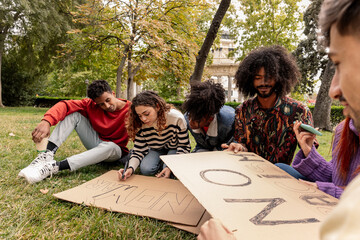 Group of multiracial young people preparing cardboard banners to demonstrate against war