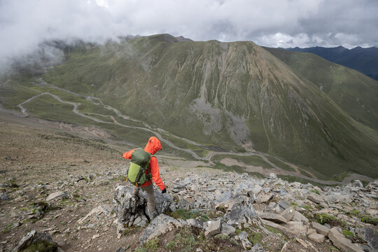 Woman hiker climbing to mountain top in tibet