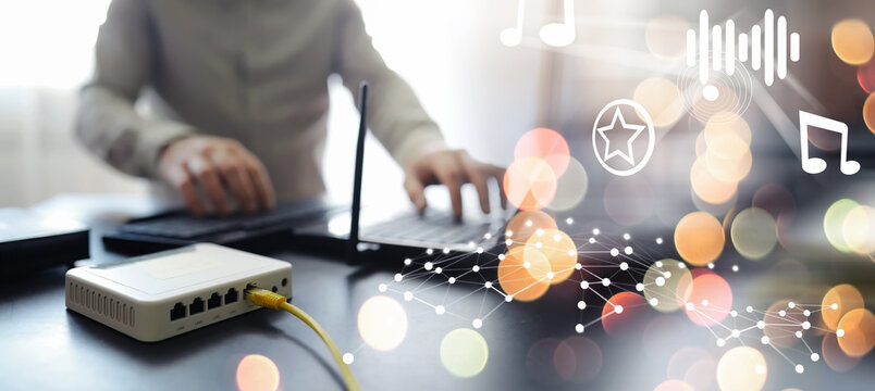 Home wireless router with ethernet cables plugged in, close up.Modern dual band wireless router. Man working in the background.