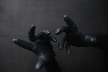 Background of hands in gloves. Black gloves. Hand gestures in black gloves.