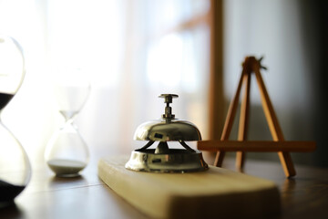 Hotel service bell on wooden reception desk. Space for text