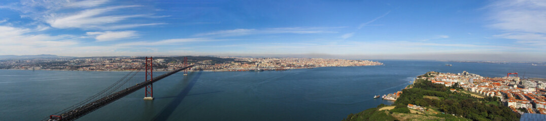 Fototapeta na wymiar 25 de Abril Bridge. One of the largest suspension bridges in the world. Connects Lisbon (top) to Almada (bottom right) over the Tagus or Tejo River. Portugal