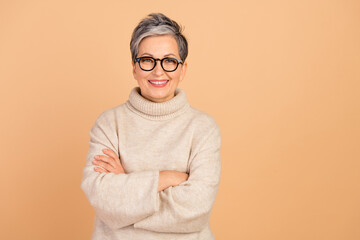 Portrait of cheerful it specialist grandmother wearing turtleneck folded hands confident leader isolated on beige color background