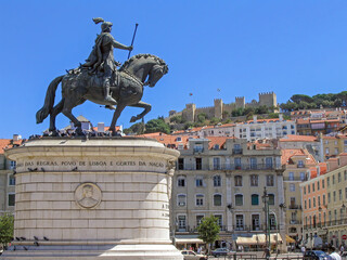 Praca da Figueira Square in the Baixa district in Lisbon , Portugal. King Dom Joao I statue with the Sao Jorge Castle on top of hill