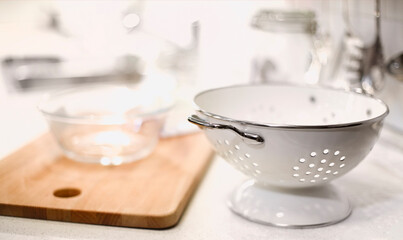 Fototapeta na wymiar White colander and kitchenware on white kitchen
