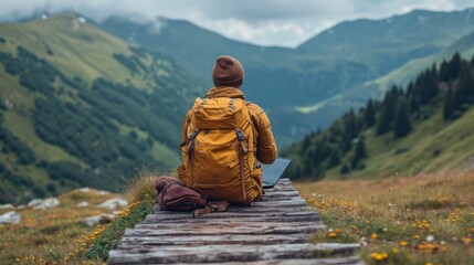 Randonneur avec ordinateur contemplant les montagnes : Évasion naturelle en jaune