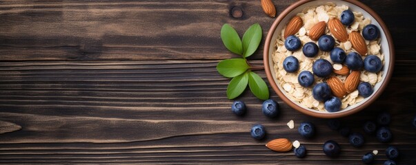 Obraz na płótnie Canvas Top view of Oatmeal porridge with fresh blueberries and almonds in a bowl on wooden table. Healthy breakfast concept