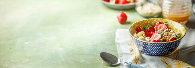 Food background with healthy breakfast porridge bowl with strawberries , front view. Banner