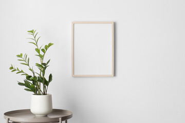 Wooden frame mockup on the wall with a zamia flower decoration.