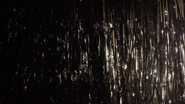 Christmas or New Year background and texture. Dark tinsel shiny ribbons.