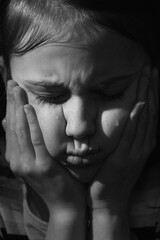 Black and white vertical portrait of crying cute little offended child girl.