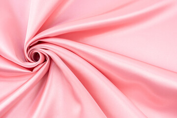 Pink color satin crumpled or wavy fabric texture background.