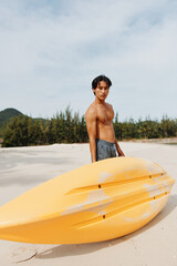 Obraz premium Happy Asian Man Enjoying Kayaking Adventure on a Tropical Beach