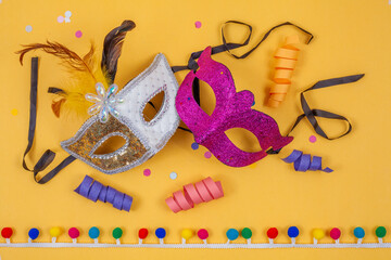 Venetian carnival masks, colorful and together, isolated on a yellow background