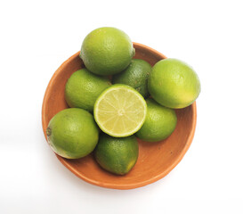 Green lemon in a clay bowl. Lemon from Brazil.