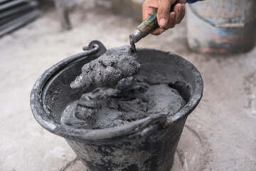 Hand worker with trowel wet Cement bucket for Masonry brick wall, Concrete Mix