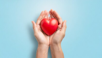 adult hands around red heart on light blue pastel background health care organ donation family life insurance world heart day world health day praying concept - obrazy, fototapety, plakaty