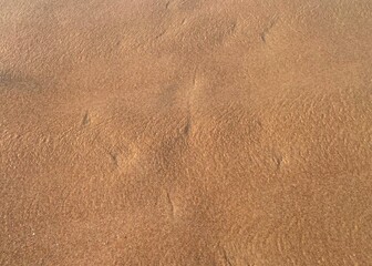 sunny Small, Soft wave on sand beach, text copy space for banners, cards. Close up top view of sea blue waves break on sand. photo was shot in evening at sunset
