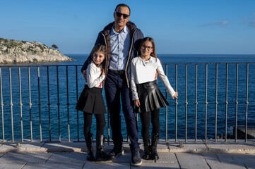 Ritratto di un papà con le figlie gemelle di nove anni.