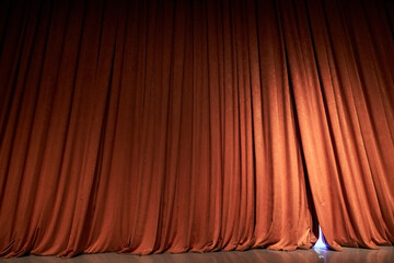 Orange closed curtain or drapes in theater with copy space. Theatrical performance concept. Spot of...