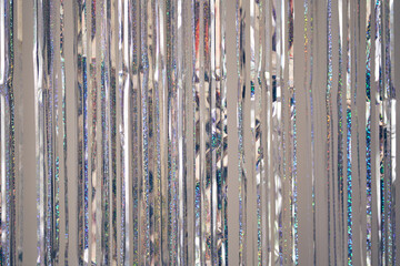 Silver fringe curtains party decoration with copy space. Metallic tinsel glitter rain background....