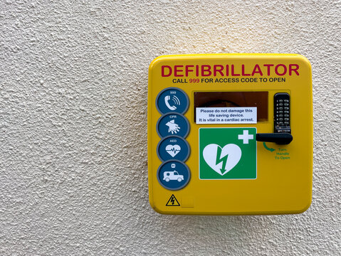 First aid heart debribrillator on a wall in a park in Cheltenham, UK