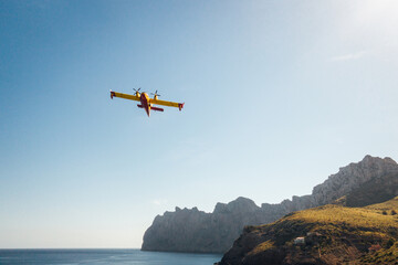 Fototapeta na wymiar Un canadair survolant l'île de Majorque. Un bombardier d'eau au dessus de Majorque. Avion luttant contre les incendies. Risque d'incendie en méditerranée.