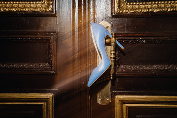 Elegant blue high heel on vintage gold door handle for classic style